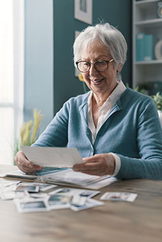 Happy senior woman looking at photos