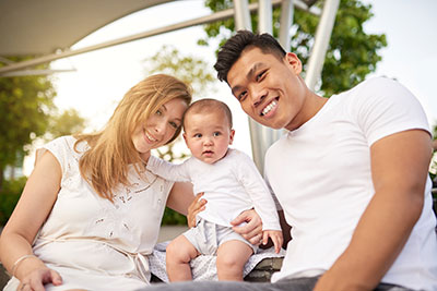 Parents sitting on their front portch with their toddler